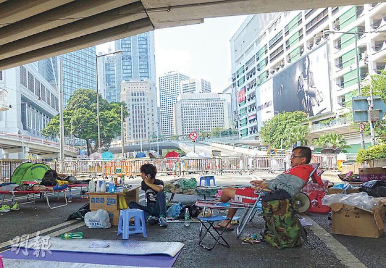 在金鐘道佔領11日的24歲音樂人Heman(左穿黑衣者)認為政府若不作出任何實質承諾,難以開放金鐘道。為佔領而辭去廚房工作的江先生(右)認為,金鐘道是通往中環和灣仔的樞紐,落實公民提名前一定要堅守。(陳顥之攝) 在金鐘道佔領11日的24歲音樂人Heman(左穿黑衣者)認為政府若不作出任何實質承諾,難以開放金鐘道。為佔領而辭去廚房工作的江先生(右)認為,金鐘道是通往中環和灣仔的樞紐,落實公民提名前一定要堅守。(陳顥之攝)