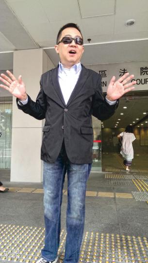 董學佳(圖)昨在庭外一人分飾兩角,親身示範案發當日自己如何與涉事攝影記者衝突,又氣憤地指摘記者的報道不夠全面。(章淑廉攝) 董學佳(圖)昨在庭外一人分飾兩角,親身示範案發當日自己如何與涉事攝影記者衝突,又氣憤地指摘記者的報道不夠全面。(章淑廉攝)