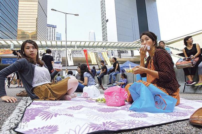金鐘集會場地成為不少港人,包括金鐘一帶上班族午飯時間散步及午膳地方,圖為昨午有穿著裙子的女子,帶備野餐布到干諾道中的馬路野餐。(李紹昌攝) 金鐘集會場地成為不少港人,包括金鐘一帶上班族午飯時間散步及午膳地方,圖為昨午有穿著裙子的女子,帶備野餐布到干諾道中的馬路野餐。(李紹昌攝)