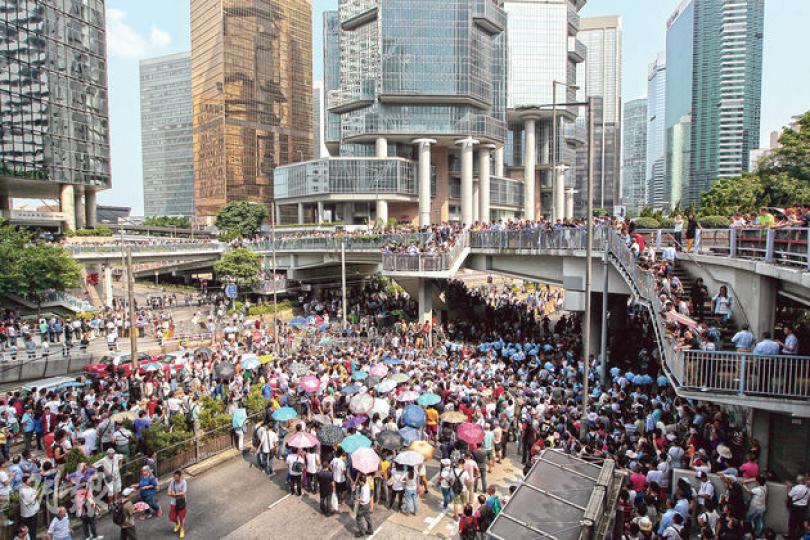 金鐘道昨午1時起突然出現大批反佔中者(左邊持傘者),他們由遮打花園步行至金鐘道與佔中支持者(圖右橋下位置)對峙;另有一批「口罩人」同時現身,部分反佔中者帶着利器,企圖拆走現場路障,雙方對峙,警員其後到場分隔兩批人。另外,有十多架的士(圖左下方)亦到場抗議,要求佔領者開路。(李澤彤攝)反佔中者移除金鐘道部分路障後,昨午不少佔中者在統一中心外搬動鐵馬,想加固路障,但隨即被便衣探員喝止,反問他們「係咪黑社會」,警員並拘捕一名在場支持佔中的人,引發示威者與警方對峙。(葉家豪攝)在金鐘道近正義道,當一名佔 金鐘道昨午1時起突然出現大批反佔中者(左邊持傘者),他們由遮打花園步行至金鐘道與佔中支持者(圖右橋下位置)對峙;另有一批「口罩人」同時現身,部分反佔中者帶着利器,企圖拆走現場路障,雙方對峙,警員其後到場分隔兩批人。另外,有十多架的士(圖左下方)亦到場抗議,要求佔領者開路。(李澤彤攝)反佔中者移除金鐘道部分路障後,昨午不少佔中者在統一中心外搬動鐵馬,想加固路障,但隨即被便衣探員喝止,反問他們「係咪黑社會」,警員並拘捕一名在場支持佔中的人,引發示威者與警方對峙。(葉家豪攝)在金鐘道近正義道,當一名佔