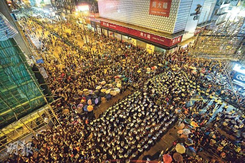 大批示威者前晚至昨晨在旺角街頭與警察「打游擊」,由於警力不足,警員築起防線後容易被示威者從四方八面的路口反包圍。圖中示威者於登打士街與彌敦道交界十字路,在四方以雨傘陣設防線,反包圍在中央列成方陣的警員。(余俊亮攝) 大批示威者前晚至昨晨在旺角街頭與警察「打游擊」,由於警力不足,警員築起防線後容易被示威者從四方八面的路口反包圍。圖中示威者於登打士街與彌敦道交界十字路,在四方以雨傘陣設防線,反包圍在中央列成方陣的警員。(余俊亮攝)
