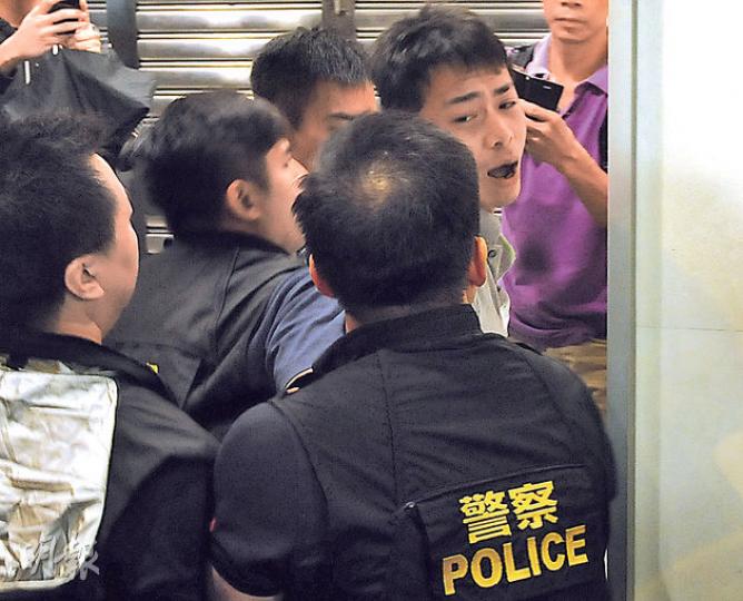 旺角彌敦道恒生大廈對出昨晨有警民對峙之際,一灰衫男子突然大叫「香港唔歡迎你呀!香港唔歡迎你啲警察呀!」隨即有數名身穿背心的便衣探員一擁而上將他制服,其間有警員曾一度使用頸鎖將男子壓至牆邊,男子狀甚痛苦,最後被帶上警車。(樊銳昌攝) 旺角彌敦道恒生大廈對出昨晨有警民對峙之際,一灰衫男子突然大叫「香港唔歡迎你呀!香港唔歡迎你啲警察呀!」隨即有數名身穿背心的便衣探員一擁而上將他制服,其間有警員曾一度使用頸鎖將男子壓至牆邊,男子狀甚痛苦,最後被帶上警車。(樊銳昌攝)