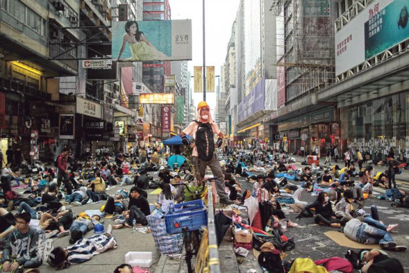 昨日清晨6時15分,警方定性為「暴亂邊緣」的旺角彌敦道「佔領區」,大部分示威者仍未睡醒過來,但仍有示威者保持警惕,監察警方一舉一動。(李澤彤攝)旺角的「佔領區」物資站內,義工正整理一些防護裝備,包括用膠樽或軟墊製成的「土炮護墊」和頭盔等,供示威者使用。(郭慶輝攝)部分示威者自製防護裝備,防禦警察的警棍擊打。警方認為,這些示威者有備而來,配備頭盔、眼罩、軟墊及手持雨傘作勢衝擊警方,不斷叫囂及辱罵警方,衝擊警方防線。(盧翊銘攝)毛孟靜(右方坐下者)昨凌晨到旺角佔領區,通宵坐於示威者與警察之間,防止雙 昨日清晨6時15分,警方定性為「暴亂邊緣」的旺角彌敦道「佔領區」,大部分示威者仍未睡醒過來,但仍有示威者保持警惕,監察警方一舉一動。(李澤彤攝)旺角的「佔領區」物資站內,義工正整理一些防護裝備,包括用膠樽或軟墊製成的「土炮護墊」和頭盔等,供示威者使用。(郭慶輝攝)部分示威者自製防護裝備,防禦警察的警棍擊打。警方認為,這些示威者有備而來,配備頭盔、眼罩、軟墊及手持雨傘作勢衝擊警方,不斷叫囂及辱罵警方,衝擊警方防線。(盧翊銘攝)毛孟靜(右方坐下者)昨凌晨到旺角佔領區,通宵坐於示威者與警察之間,防止雙