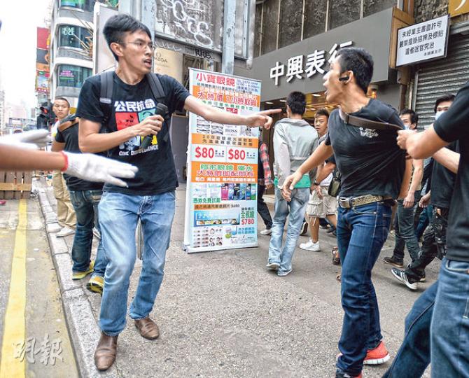 其中一名黑衣男(右)昨跳起揮拳打向社民連副主席吳文遠(左),最後逃去。(盧翊銘攝) 其中一名黑衣男(右)昨跳起揮拳打向社民連副主席吳文遠(左),最後逃去。(盧翊銘攝)