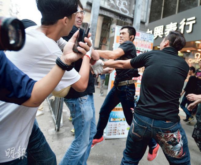 旺角佔領區昨午3時許發生衝突,社民連副主席吳文遠(左邊帶眼鏡者)疑被反佔中者襲擊,稱在混亂中有反佔中者向他們擲石。他即時報警求助,稱警方曾拖延,遲遲不肯處理,令他「要自己捉賊」。(盧翊銘攝)10多名黑衣口罩漢昨突現身旺角彌敦道,腳踢作為路障的回收箱,又拾起地上木條,擊向回收箱至木條折斷。(盧翊銘攝)一名經常手持漫畫人物「美國隊長」盾牌、戴頭盔和眼罩的31歲男子,昨在旺角涉用盾牌推跌一名正在拆路障的51歲白頭男子,涉普通襲擊被拘捕。(李紹昌攝)近日反佔中示威常客之一,包括昨日在旺角身繫「紅絲帶」、 旺角佔領區昨午3時許發生衝突,社民連副主席吳文遠(左邊帶眼鏡者)疑被反佔中者襲擊,稱在混亂中有反佔中者向他們擲石。他即時報警求助,稱警方曾拖延,遲遲不肯處理,令他「要自己捉賊」。(盧翊銘攝)10多名黑衣口罩漢昨突現身旺角彌敦道,腳踢作為路障的回收箱,又拾起地上木條,擊向回收箱至木條折斷。(盧翊銘攝)一名經常手持漫畫人物「美國隊長」盾牌、戴頭盔和眼罩的31歲男子,昨在旺角涉用盾牌推跌一名正在拆路障的51歲白頭男子,涉普通襲擊被拘捕。(李紹昌攝)近日反佔中示威常客之一,包括昨日在旺角身繫「紅絲帶」、