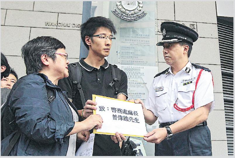 6個傳媒工會昨到灣仔警總遞交請願信,要求徹查記者採訪「藍絲帶」集會遇襲事件,由助理警務處長李建輝(右)接信。記協主席岑倚蘭(左)對事件感震驚及憤怒,但對暫停採訪藍絲帶活動有保留。中為早前採訪時被反佔中者打傷的港台記者麥嘉緯。(李澤彤攝)藍絲帶運動召集人李偲嫣(前右二)昨回應稱,打記者事件是獨立參與晚會者引起,與藍絲帶運動無關,並指活動有採訪區,稱記者在採訪時「走嚟走去」。(余俊亮攝) 6個傳媒工會昨到灣仔警總遞交請願信,要求徹查記者採訪「藍絲帶」集會遇襲事件,由助理警務處長李建輝(右)接信。記協主席岑倚蘭(左)對事件感震驚及憤怒,但對暫停採訪藍絲帶活動有保留。中為早前採訪時被反佔中者打傷的港台記者麥嘉緯。(李澤彤攝)藍絲帶運動召集人李偲嫣(前右二)昨回應稱,打記者事件是獨立參與晚會者引起,與藍絲帶運動無關,並指活動有採訪區,稱記者在採訪時「走嚟走去」。(余俊亮攝)