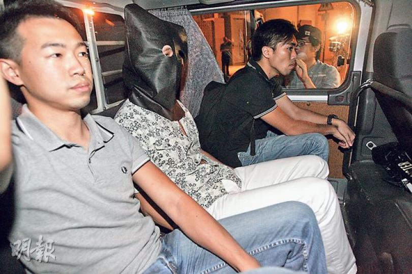 警方昨日再拘捕一名徐姓男子（蒙頭者），涉嫌與上周六晚尖沙嘴撐警集會的打記者案有關。（伍浦鋒攝）