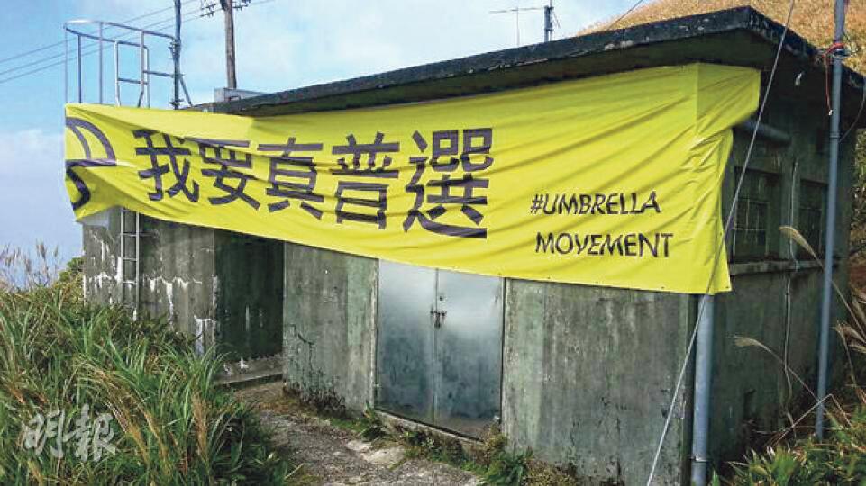 繼獅子山及飛鵝山被人掛上「我要真普選」直幡後,大帽山山頂亦出現「我要真普選」橫額。(衛永康攝)飛鵝山一幅峭壁掛有一幅長20米的「我要真普選」黃色直幡,昨午消防處派出8名高空拯救專隊人員和5名民安隊員,由崖頂游繩至直幡底部拆走直幡。(衛永康攝) 繼獅子山及飛鵝山被人掛上「我要真普選」直幡後,大帽山山頂亦出現「我要真普選」橫額。(衛永康攝)飛鵝山一幅峭壁掛有一幅長20米的「我要真普選」黃色直幡,昨午消防處派出8名高空拯救專隊人員和5名民安隊員,由崖頂游繩至直幡底部拆走直幡。(衛永康攝)