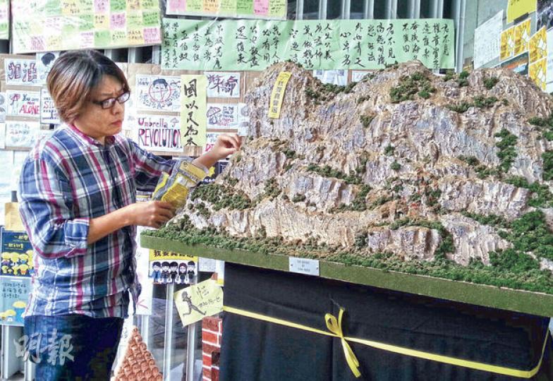 教人砌高達模型嘅Ray(圖),花咗一星期做咗呢個獅子山掛上「我要真普選」直幡嘅模型。(岑詠欣攝)細心睇,獅子山模型暗藏咗一個高達模型。(李澤彤攝) 教人砌高達模型嘅Ray(圖),花咗一星期做咗呢個獅子山掛上「我要真普選」直幡嘅模型。(岑詠欣攝)細心睇,獅子山模型暗藏咗一個高達模型。(李澤彤攝)
