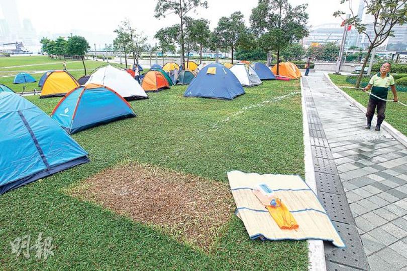 記者觀察所見,金鐘添馬公園草地上置有40多個帳幕,在留守者移開帳幕後,草地留下一幅綠草變枯黃的方形泥地。草皮專家李賢祉說,只要恢復澆水,讓泥土內殘留的草根重新生長,便會回復一片綠油油。(郭慶輝攝) 記者觀察所見,金鐘添馬公園草地上置有40多個帳幕,在留守者移開帳幕後,草地留下一幅綠草變枯黃的方形泥地。草皮專家李賢祉說,只要恢復澆水,讓泥土內殘留的草根重新生長,便會回復一片綠油油。(郭慶輝攝)