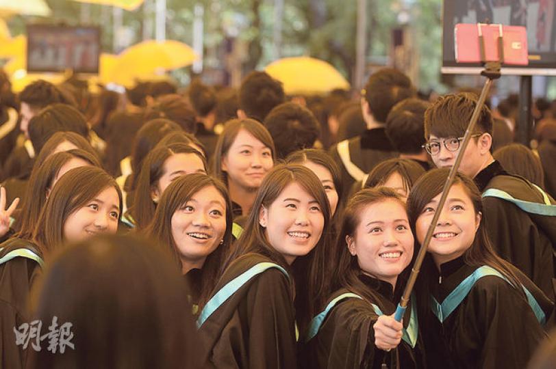 中文大學昨日舉行畢業禮,有畢業生以「黄傘海」作為背景自拍留念。(盧翊銘攝) 中文大學昨日舉行畢業禮,有畢業生以「黄傘海」作為背景自拍留念。(盧翊銘攝)