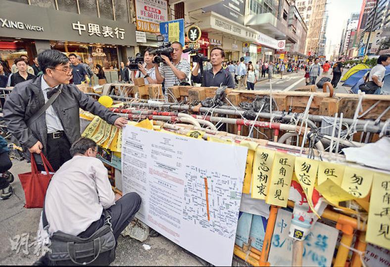 執達主任及的士團體代表昨午沿旺角彌敦道張貼禁制令,包括圖中附有地圖的「大字版」禁制令及中譯版文本,呼籲佔領者24小時內收拾個人物品。至於申請亞皆老街禁制令的「潮聯小巴」,其代表今早9時將聯同執達主任及警方到有關路段清理路障,據悉警方將部署3000警力協助,包括近千反黑探員嚴防黑幫「搞事」。(盧翊銘攝)代表的士團體的律師樓人員及司法機構的執達主任,昨午2時半沿旺角彌敦道於11處障礙物張貼禁制令,用索帶及膠紙固定,並派發告示,呼籲佔領者24小時內收拾物品。(盧翊銘攝)(明報製圖) 執達主任及的士團體代表昨午沿旺角彌敦道張貼禁制令,包括圖中附有地圖的「大字版」禁制令及中譯版文本,呼籲佔領者24小時內收拾個人物品。至於申請亞皆老街禁制令的「潮聯小巴」,其代表今早9時將聯同執達主任及警方到有關路段清理路障,據悉警方將部署3000警力協助,包括近千反黑探員嚴防黑幫「搞事」。(盧翊銘攝)代表的士團體的律師樓人員及司法機構的執達主任,昨午2時半沿旺角彌敦道於11處障礙物張貼禁制令,用索帶及膠紙固定,並派發告示,呼籲佔領者24小時內收拾物品。(盧翊銘攝)(明報製圖)