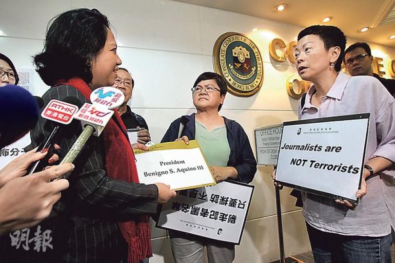香港記者協會主席岑倚蘭(中)及副主席任美貞(前右)等成員,昨帶同「記者不是恐怖分子」等標語,到菲律賓駐港領事館向總領事嘉謹(前左)遞信,要求菲方移除入境黑名單。(林俊源攝) 香港記者協會主席岑倚蘭(中)及副主席任美貞(前右)等成員,昨帶同「記者不是恐怖分子」等標語,到菲律賓駐港領事館向總領事嘉謹(前左)遞信,要求菲方移除入境黑名單。(林俊源攝)
