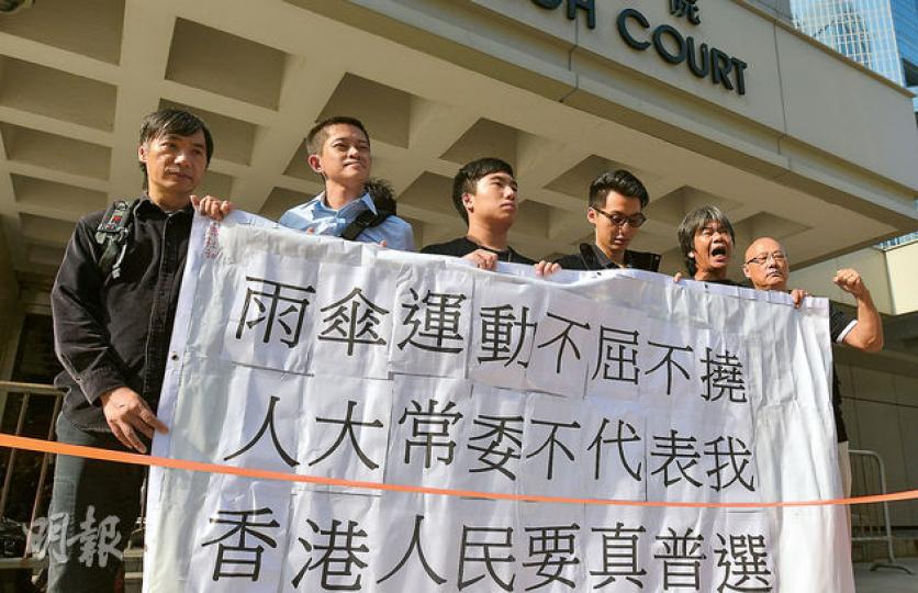 包括立法會議員梁國雄(右二)在內的21名因涉嫌藐視法庭被捕的人昨首次到高院應訊,梁國雄及支持被捕者的議員陳偉業(右一)等在聆訊前拉起橫額,高喊「雨傘運動,不屈不撓」等口號。(黃志東攝) 包括立法會議員梁國雄(右二)在內的21名因涉嫌藐視法庭被捕的人昨首次到高院應訊,梁國雄及支持被捕者的議員陳偉業(右一)等在聆訊前拉起橫額,高喊「雨傘運動,不屈不撓」等口號。(黃志東攝)