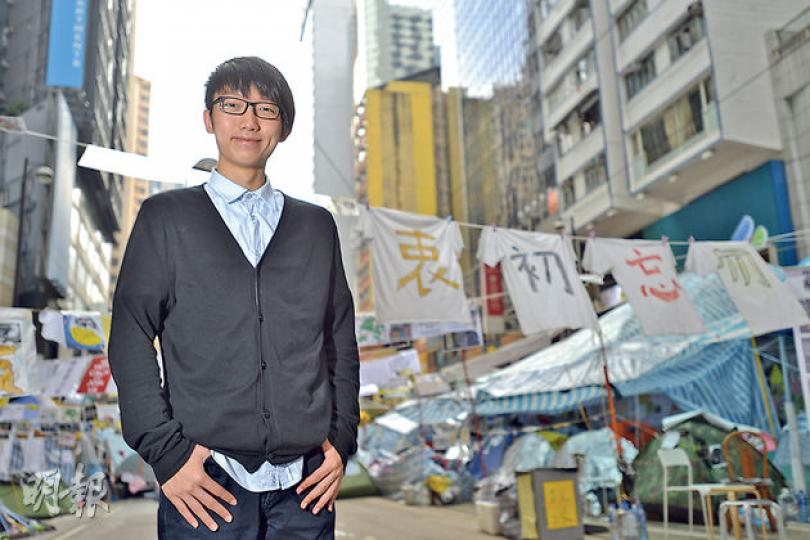 張崑陽在銅鑼灣佔領區擔大旗，曾攔截突如其來夾走路障和物資的「夾斗車」。據了解，浸大現時至少有兩批同學自組內閣參選，他最終能否在學生會擔大旗仍是未知之數。（黃志東攝）