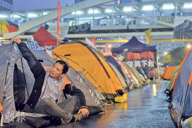 當上立法會議員並無令民主黨胡志偉變得更「尊貴」,自首當晚正下雨,記者希望他到曾睡了約一個月的佔領區拍攝,胡志偉二話不說動手搬動帳篷,笑言﹕「都無濕晒,比我想像中好喎」,更隨即坐下,褲子濕透。(鄧宗弘攝) 當上立法會議員並無令民主黨胡志偉變得更「尊貴」,自首當晚正下雨,記者希望他到曾睡了約一個月的佔領區拍攝,胡志偉二話不說動手搬動帳篷,笑言﹕「都無濕晒,比我想像中好喎」,更隨即坐下,褲子濕透。(鄧宗弘攝)