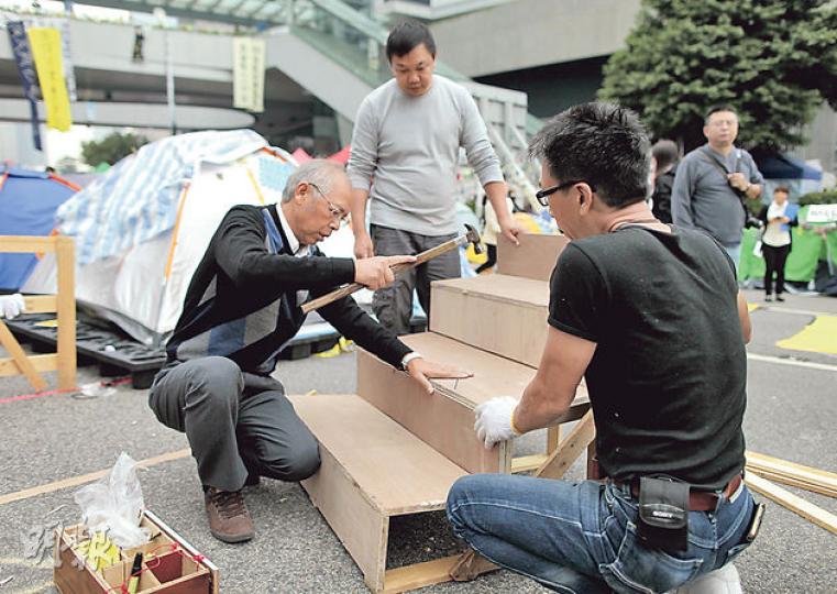 剛度過68歲生日的陳伯(圖)昨午專程由澳門趕回港,見證金鐘佔領區「最後一天」,甫到埗即跟義工落手落腳修補一道破損木梯,他笑言﹕「就算最後一日,都不可以搞到人跌親嘛。」(李澤彤攝)清場前夕,金鐘佔領區昨午人頭湧湧,不少在附近上班的白領舉起手機到處留影。(李澤彤攝) 剛度過68歲生日的陳伯(圖)昨午專程由澳門趕回港,見證金鐘佔領區「最後一天」,甫到埗即跟義工落手落腳修補一道破損木梯,他笑言﹕「就算最後一日,都不可以搞到人跌親嘛。」(李澤彤攝)清場前夕,金鐘佔領區昨午人頭湧湧,不少在附近上班的白領舉起手機到處留影。(李澤彤攝)