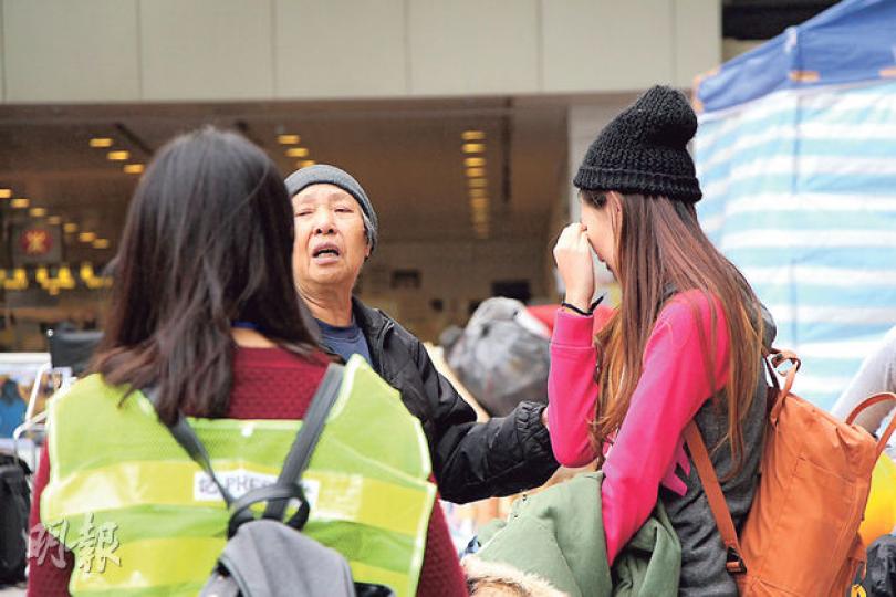 82歲麥婆婆(中)昨力勸一名女大學生(右)離開現場,不要因被捕而無法上學,自己卻決意留下、甘願被捕,一度令女學生感動得哭成淚人。(周偉強攝)警方昨出動數以千計警員清場,縱然警員重重列陣包圍,仍有一名留守的女士不願離場,悠然自得地坐在干諾道中石壆上看書。(郭慶輝攝)被捕者中最高齡的90歲黃伯(右)表明無懼拘捕,他昨在警員攙扶下,拄着拐杖自行登上警方旅遊巴。(盧翊銘攝) 82歲麥婆婆(中)昨力勸一名女大學生(右)離開現場,不要因被捕而無法上學,自己卻決意留下、甘願被捕,一度令女學生感動得哭成淚人。(周偉強攝)警方昨出動數以千計警員清場,縱然警員重重列陣包圍,仍有一名留守的女士不願離場,悠然自得地坐在干諾道中石壆上看書。(郭慶輝攝)被捕者中最高齡的90歲黃伯(右)表明無懼拘捕,他昨在警員攙扶下,拄着拐杖自行登上警方旅遊巴。(盧翊銘攝)