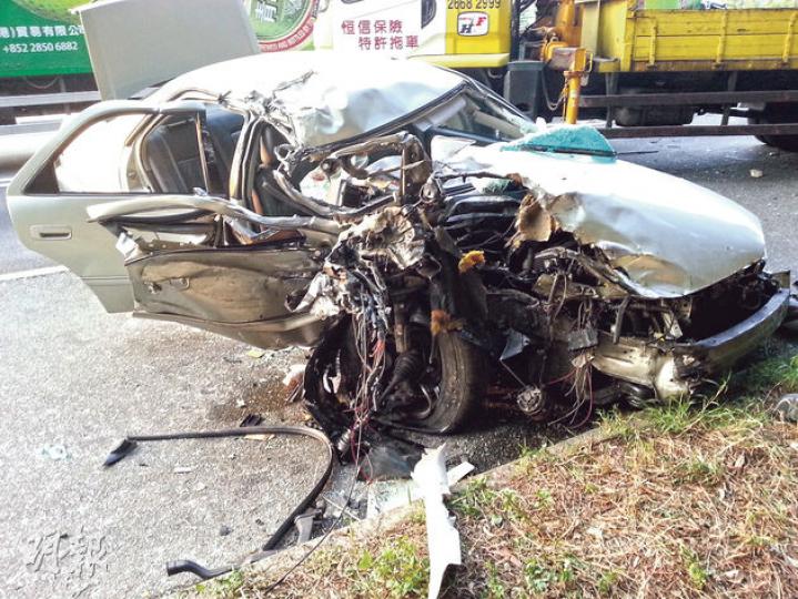 越線的私家車與貨車猛撞後,右邊車頭與駕駛座嚴重損毁,男司機被困,被救出後命危。 (衛永康攝) 越線的私家車與貨車猛撞後,右邊車頭與駕駛座嚴重損毁,男司機被困,被救出後命危。 (衛永康攝)