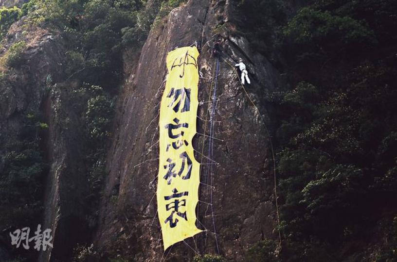 太平山峭壁上出現「勿忘初衷」6米長黃色直幡。昨日有人到該處攀石,一度被誤以為是懸掛直幡者。(鍾炳然攝) 太平山峭壁上出現「勿忘初衷」6米長黃色直幡。昨日有人到該處攀石,一度被誤以為是懸掛直幡者。(鍾炳然攝)