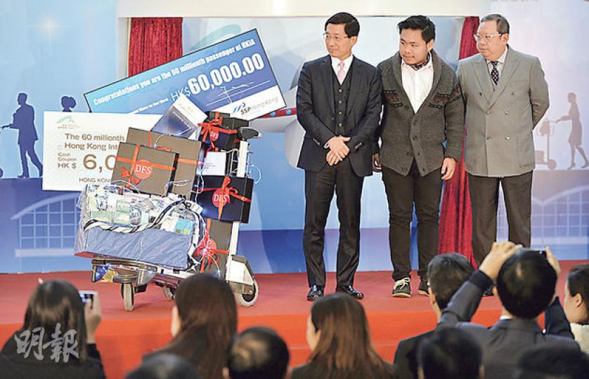 香港國際機場宣布年客運量突破6000萬人次,昨舉行慶祝典禮,第6000萬名旅客張先生(中)在機管局行政總裁林天福(左)及旅發局主席林建岳(右)陪同下,上台接受禮品。(余俊亮攝) 香港國際機場宣布年客運量突破6000萬人次,昨舉行慶祝典禮,第6000萬名旅客張先生(中)在機管局行政總裁林天福(左)及旅發局主席林建岳(右)陪同下,上台接受禮品。(余俊亮攝)