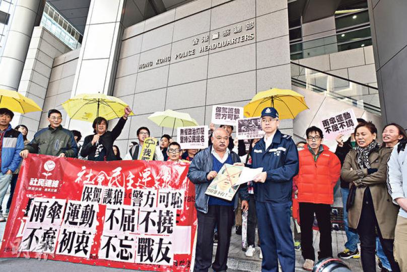 社民連昨到灣仔警總外抗議警方在佔領運動中使用過分武力,並要求警務處長曾偉雄下台,社民連成員曾健成向警方代表(圖)遞交請願信,警方一度拒收印有「曾偉雄下台」的頭像紙牌。(陳淑安攝) 社民連昨到灣仔警總外抗議警方在佔領運動中使用過分武力,並要求警務處長曾偉雄下台,社民連成員曾健成向警方代表(圖)遞交請願信,警方一度拒收印有「曾偉雄下台」的頭像紙牌。(陳淑安攝)
