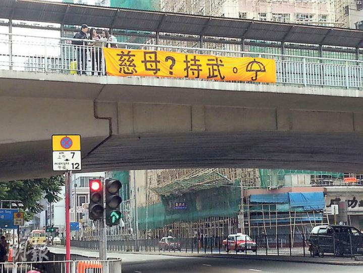 旺角亞皆老街近火車站嘅行人天橋,噚日出現一條「慈母?持武。」橫額,相信唔少當區警察行beat時都會睇到。(衛永康攝) 旺角亞皆老街近火車站嘅行人天橋,噚日出現一條「慈母?持武。」橫額,相信唔少當區警察行beat時都會睇到。(衛永康攝)