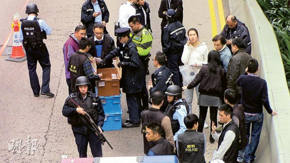 警方事後在場拾回3個載錢膠箱，並即時收集和點算現金，大批警員穿著避彈衣及荷槍實彈戒備，氣氛緊張。（鍾炳然攝）