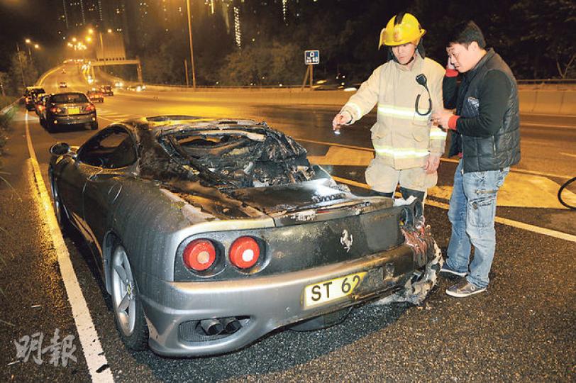 車齡近14年的法拉利跑車行駛途中突然「自焚」，車尾嚴重焚毁，司機兼車主及時逃出，在場協助調查。（蔡方山攝）