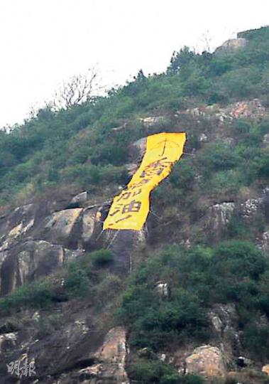魔鬼山峭壁昨晨出現「香港加油」的黃色直幡,當中有雨傘圖案。(林智傑攝) 魔鬼山峭壁昨晨出現「香港加油」的黃色直幡,當中有雨傘圖案。(林智傑攝)