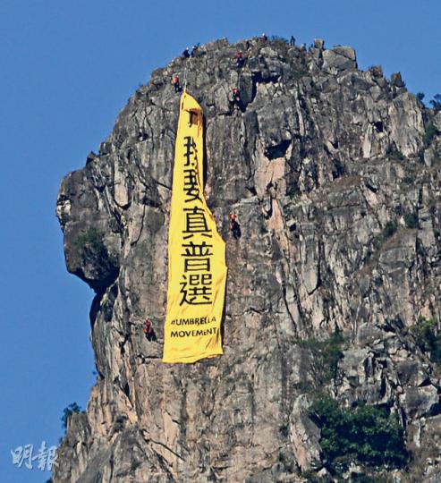 直幡懸掛5個多小時後,由消防高空拯救專隊人員游繩而下拆去。(黃志東攝) 直幡懸掛5個多小時後,由消防高空拯救專隊人員游繩而下拆去。(黃志東攝)