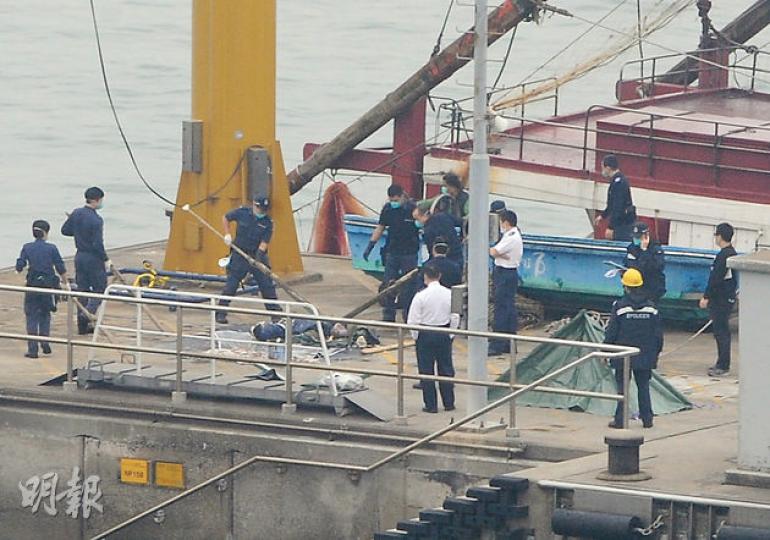 涉事香港漁船在內地水域撈魚變撈屍，事後「連網帶屍」遭拖返香港大欖水警基地，警方把屍體吊上岸調查，初步無可疑，但死者身分及死因有待確定。（蔡方山攝）