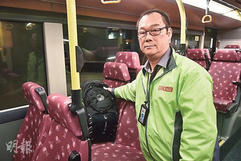 九巴車長梁華昌（圖）以另一個黑色背囊示範，講述在巴士上拾獲巨款的經過。（賴俊傑攝）九巴車長梁華昌（左）拾獲塞滿鈔票的背囊後，毫不猶疑交到站長室，由站長楊堅中即時點算，巨款最終火速物歸原主。圖中背囊只作示範，與事件無關。（賴俊傑攝）