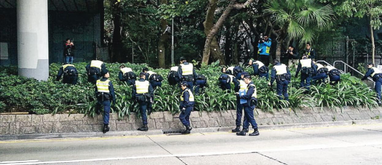 紅磡漆咸道南發生警長開4槍案件後,警方封鎖現場路面,派出大批警員在馬路及花槽地氈式搜索,尋找彈頭及證物。 (衛永康攝) 紅磡漆咸道南發生警長開4槍案件後,警方封鎖現場路面,派出大批警員在馬路及花槽地氈式搜索,尋找彈頭及證物。 (衛永康攝)