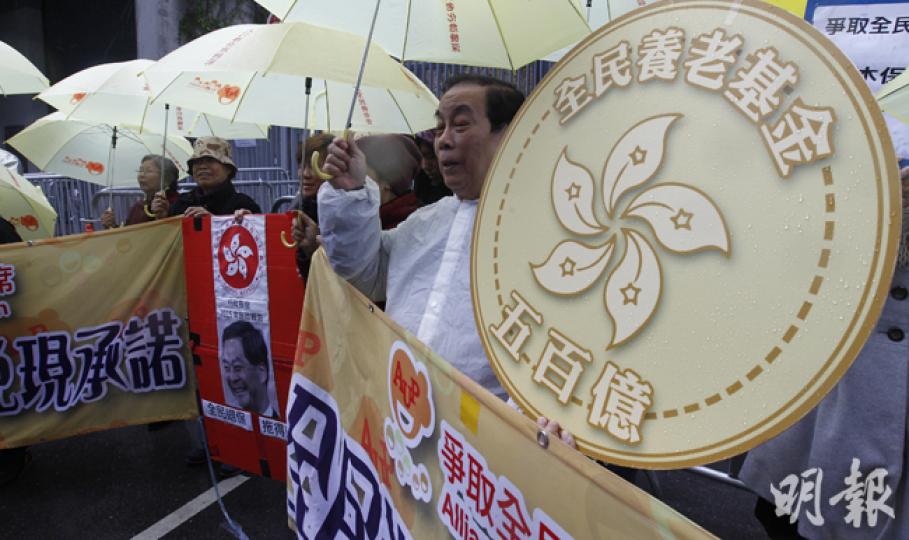 特首梁振英今日會發表任內第三份《施政報告》，消息稱他擬提出預留500億元作退休保障用途。無獨有偶，爭取全民退休保障聯席成員，昨日亦帶同一個500億元的道具錢幣，要求政府推行「全民退保」。不過，政府有意檢討退保制度，不代表要做到「全民退保」，政府將就退保制度及款項用途諮詢公眾。（李紹昌攝）梁振英今將宣讀任內第3份《施政報告》，多個政黨和民間團體昨趁行會開會前「最後衝刺」提出意見。其中民協批評梁打算將新落成公屋「整幢」向綠表公屋家庭出售，指為罔顧26萬正輪候公屋的市民。（李紹昌攝）
