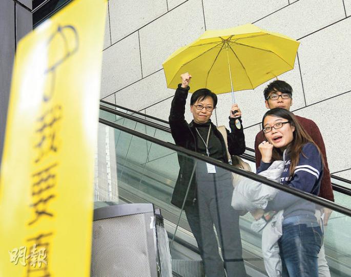 工黨立法會議員何秀蘭(左)、學聯常務秘書鍾耀華(後右)及常委梁麗幗(前)昨到警察總部按「預約」被捕,有市民舉黃傘及「我要真普選」標語聲援。3人與另一學聯常委張秀賢、工黨李卓人及公民黨梁家傑,作供後分別成功「踢保」,獲無條件釋放,但警方保留檢控權利。(李紹昌攝) 工黨立法會議員何秀蘭(左)、學聯常務秘書鍾耀華(後右)及常委梁麗幗(前)昨到警察總部按「預約」被捕,有市民舉黃傘及「我要真普選」標語聲援。3人與另一學聯常委張秀賢、工黨李卓人及公民黨梁家傑,作供後分別成功「踢保」,獲無條件釋放,但警方保留檢控權利。(李紹昌攝)