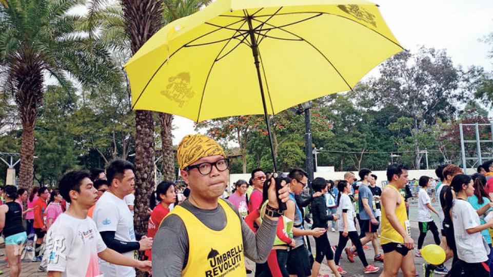 全程撐傘跑10公里賽的黃先生說自己沿途撐傘，聽到有人對他說「唔好阻住」，他未有理會繼續表達訴求。（林婉斐攝）梁先生在衝線時手執「我要真普選」標語，認為政治表態行為不會干擾馬拉松，賽道亦算空曠，相信不會滋擾到其他跑手。（陳顥之攝）曾先生說今年改道，沿途有撐佔領者打氣「好熱鬧」，認為示威活動在賽道外進行不會妨礙跑手。（陳顥之攝）吳先生認為，示威活動只要不影響跑手就沒問題，就像歷屆有人穿鯊魚裝宣揚保護鯊魚一樣。（陳顥之攝）