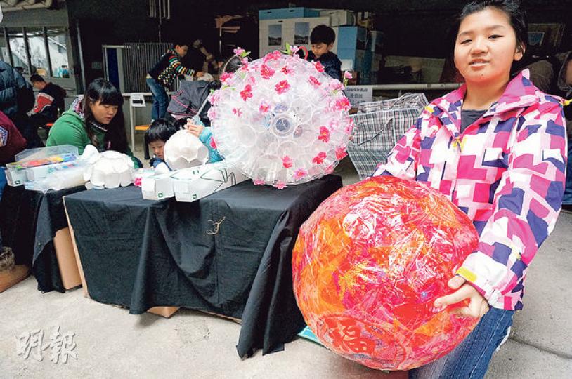 14歲的琪琪(右)手持其親自設計、以膠杯製成的「花火燈」。為了迎合新年氣氛,她為「花火燈」加上紅色的玻璃紙及金粉,內裏加上小燈泡,讓「花火燈」於黑暗中發出淡淡紅光。(黎明芝攝) 14歲的琪琪(右)手持其親自設計、以膠杯製成的「花火燈」。為了迎合新年氣氛,她為「花火燈」加上紅色的玻璃紙及金粉,內裏加上小燈泡,讓「花火燈」於黑暗中發出淡淡紅光。(黎明芝攝)
