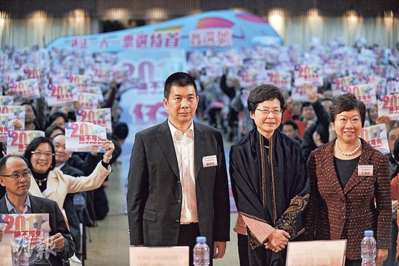 政務司長林鄭月娥昨晚出席九龍各界政改交流會,台下市民舉起普選單張,以示支持政改通過、落實普選。左為全國政協委員譚錦球,右為九龍社團聯會理事長王惠貞。(葉家豪攝) 政務司長林鄭月娥昨晚出席九龍各界政改交流會,台下市民舉起普選單張,以示支持政改通過、落實普選。左為全國政協委員譚錦球,右為九龍社團聯會理事長王惠貞。(葉家豪攝)
