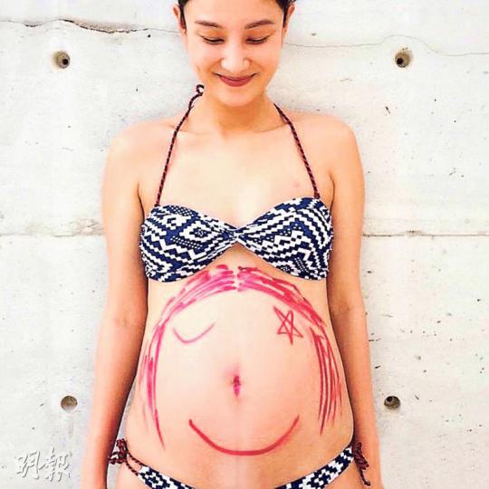 已經懷孕逾7個月的Yumiko,在巨肚畫上BB女的笑臉。(微博圖片) 已經懷孕逾7個月的Yumiko,在巨肚畫上BB女的笑臉。(微博圖片)