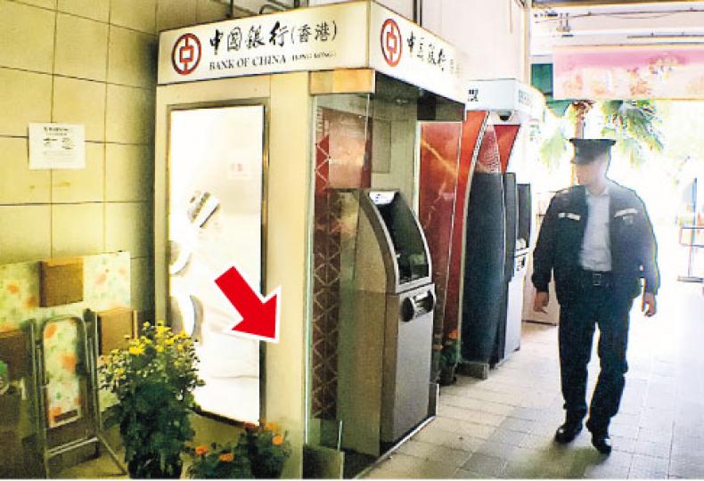 石硤尾南山邨街市的中銀櫃員機旁(箭嘴示),昨早有解款員遺下一支雷明登霰彈槍,昨午有警員到場巡邏。(林智傑攝) 石硤尾南山邨街市的中銀櫃員機旁(箭嘴示),昨早有解款員遺下一支雷明登霰彈槍,昨午有警員到場巡邏。(林智傑攝)