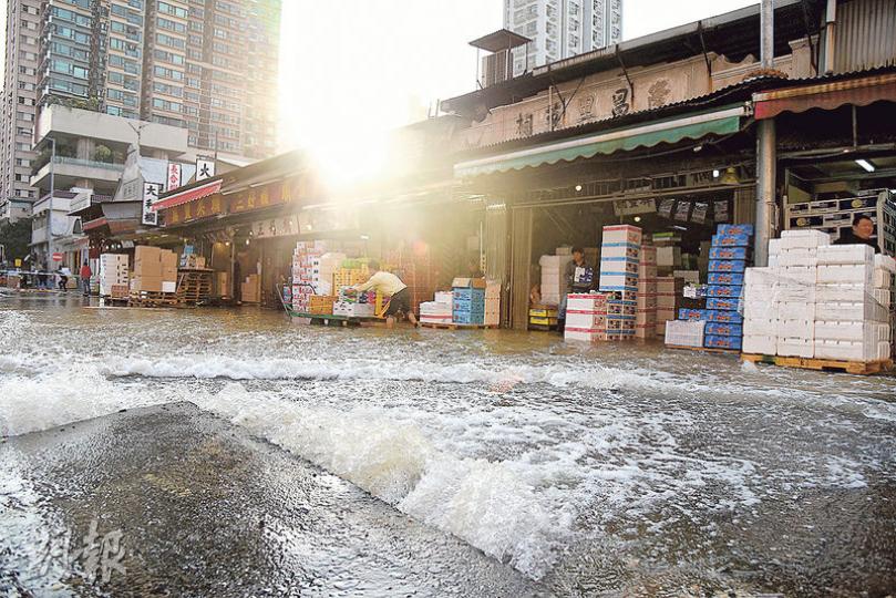 油麻地果欄對開路面昨晨爆水管,路面頓成澤國,果欄工人忙於推走水果,以減低損失。(蔡方山攝) 油麻地果欄對開路面昨晨爆水管,路面頓成澤國,果欄工人忙於推走水果,以減低損失。(蔡方山攝)