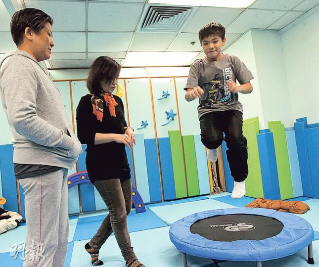 9歲康復者劉韋信(右)接受治療初期,常與治療師在這房間進行體力活動,並傾談備受困擾的創傷經歷。他治療初期連跳彈牀也覺恐懼,但康復後敢於嘗試各種挑戰。(李紹昌攝) 9歲康復者劉韋信(右)接受治療初期,常與治療師在這房間進行體力活動,並傾談備受困擾的創傷經歷。他治療初期連跳彈牀也覺恐懼,但康復後敢於嘗試各種挑戰。(李紹昌攝)