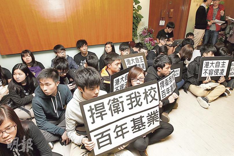 近60名港大生昨穿黑衣到校委會會議場地外靜坐,部分學生手持「捍衛我校百年基業」及「港大自主不容侵凌」等標語,要求校委會堅守「能者居之」原則選任副校長,不容政治干預。(李紹昌攝) 近60名港大生昨穿黑衣到校委會會議場地外靜坐,部分學生手持「捍衛我校百年基業」及「港大自主不容侵凌」等標語,要求校委會堅守「能者居之」原則選任副校長,不容政治干預。(李紹昌攝)