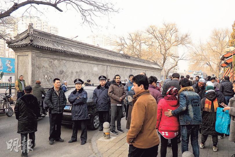 周五下午，禮拜寺外都會聚集城管等執法人員，等待禮拜結束人群散去。（麥俊攝）