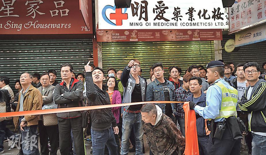 警方在藥房林立的元朗壽富街拉起封鎖線,分隔反水貨客示威者及旁觀市民。有人指罵示威者,又向他們舉起中指粗口手勢。(余俊亮攝) 警方在藥房林立的元朗壽富街拉起封鎖線,分隔反水貨客示威者及旁觀市民。有人指罵示威者,又向他們舉起中指粗口手勢。(余俊亮攝)