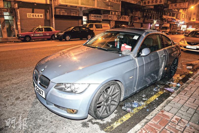 寶馬跑車遭人淋潑起漆水後甩油,車主急用清水冲洗稀釋,現場地面留下數個水樽。(蔡方山攝) 寶馬跑車遭人淋潑起漆水後甩油,車主急用清水冲洗稀釋,現場地面留下數個水樽。(蔡方山攝)
