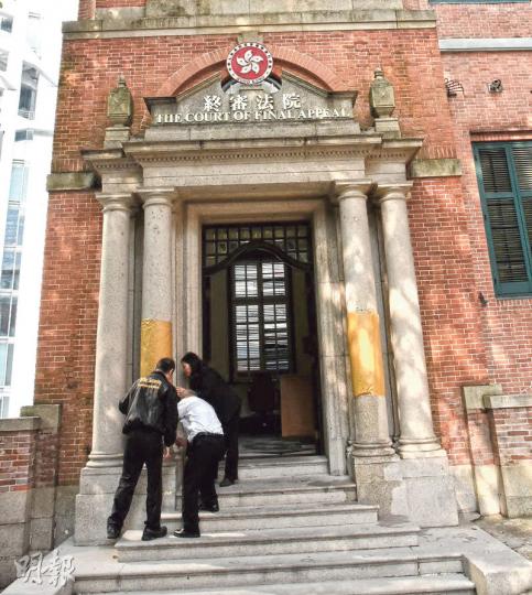 終審法院前身是法國外方傳道會大樓,1917年落成,1989年列為法定古蹟。終院正門左右兩根石柱昨晨被發現遭人以黑筆塗鴉,職員以紙遮蓋。(鍾炳然攝)終院對面的大樹樹幹,亦被人以黑筆寫上「香港司法 不公平」字句。(劉焌陶攝) 終審法院前身是法國外方傳道會大樓,1917年落成,1989年列為法定古蹟。終院正門左右兩根石柱昨晨被發現遭人以黑筆塗鴉,職員以紙遮蓋。(鍾炳然攝)終院對面的大樹樹幹,亦被人以黑筆寫上「香港司法 不公平」字句。(劉焌陶攝)