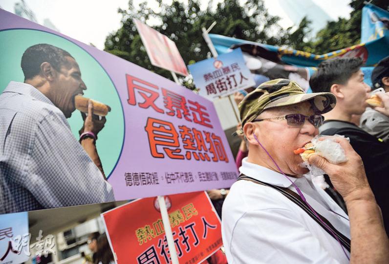 「反熱血反港獨遊行」出發前,大會派發100個熱狗,與遊行人士一齊食「熱狗」作起步儀式。大會以「熱狗」比喻為民間組織「熱血公民」,批評熱血公民利用年輕人發起多次反水貨客暴力行動,破壞社會秩序。(盧翊銘攝) 「反熱血反港獨遊行」出發前,大會派發100個熱狗,與遊行人士一齊食「熱狗」作起步儀式。大會以「熱狗」比喻為民間組織「熱血公民」,批評熱血公民利用年輕人發起多次反水貨客暴力行動,破壞社會秩序。(盧翊銘攝)