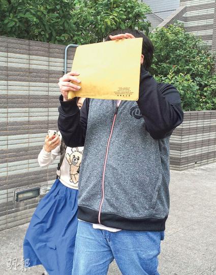補習男教師莊偉文(圖)昨承認非禮15歲女學生,獲准保釋候判,離開法院時他以文件遮面。(黃建邦攝) 補習男教師莊偉文(圖)昨承認非禮15歲女學生,獲准保釋候判,離開法院時他以文件遮面。(黃建邦攝)